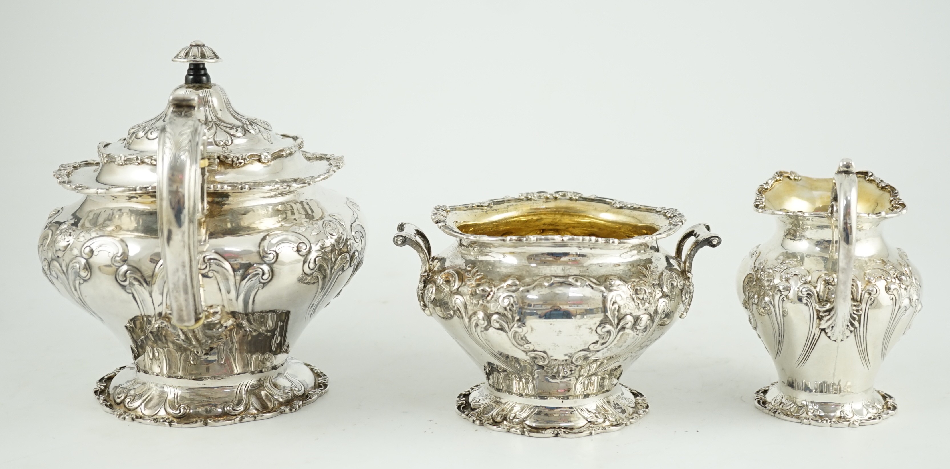An Edwardian Scottish repousse silver three piece tea set, by Robert Scott